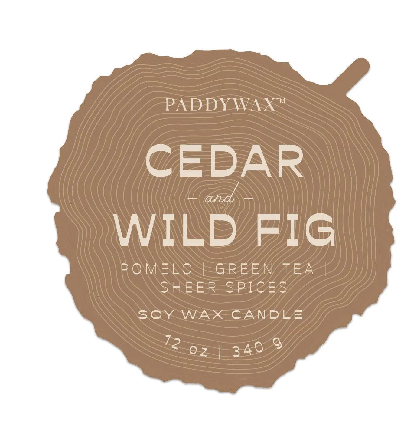 A label shaped like a tree ring slice features “Wild Fig & Cedar - Grain 12 oz Candle” in white on brown, evoking the natural beauty of woodgrain candles.