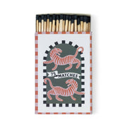 The A Dopo "Tiger" - 75ct Boxed Matches come in an open box with black-tipped matches, two orange-striped tigers facing opposite directions, and a 75 MATCHES banner on a dark green checkered background—ideal for lighting your favorite candle.