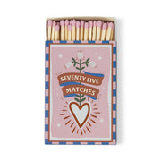 The A Dopo "Hearts" 75ct Boxed Matches feature a pink, blue, and white box adorned with a heart, flowers, and ribbon. Pink-tipped safety matches add charm to your candle setup or as a Mediterranean-inspired keepsake.