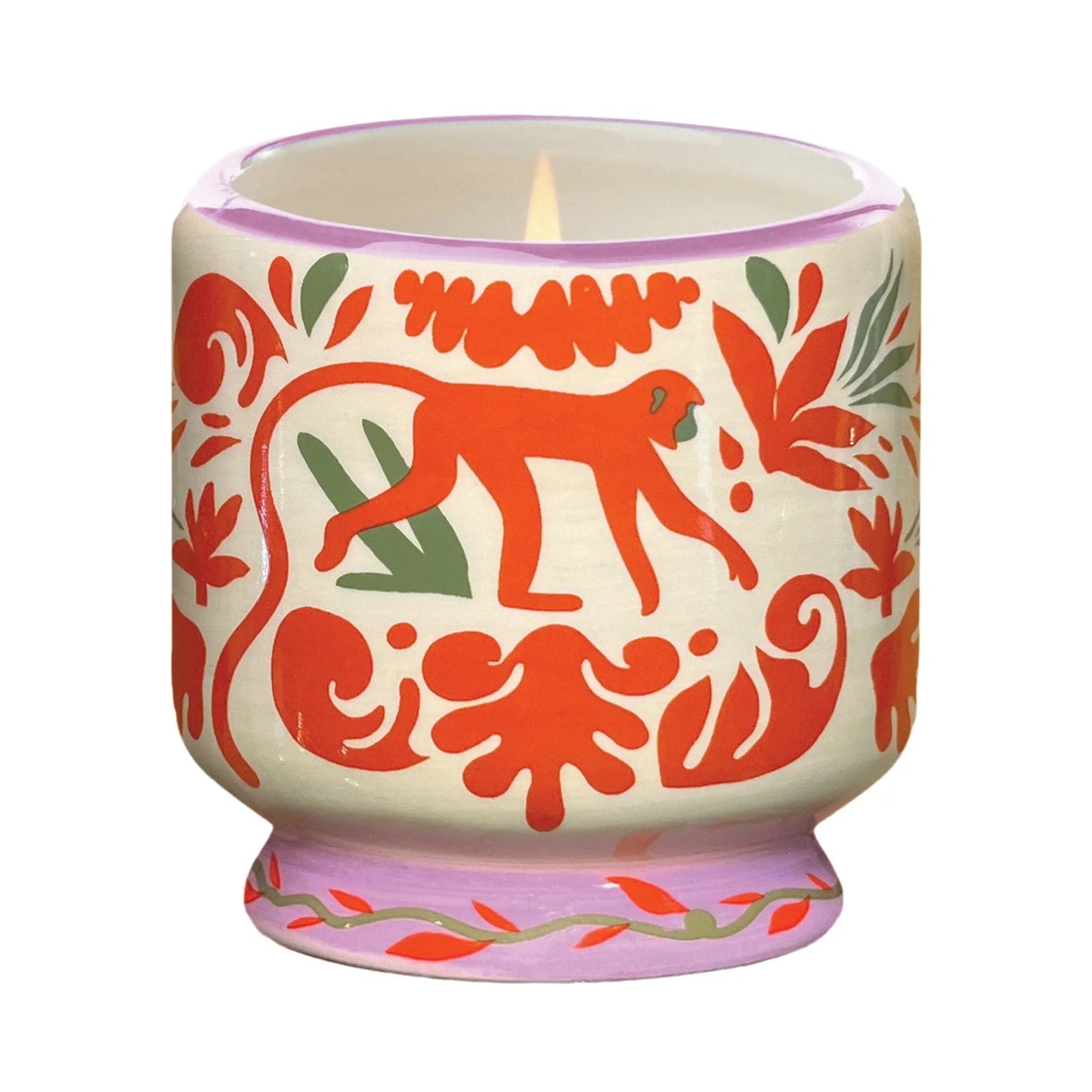 The Coconut & Amber - A Dopo 8 oz Candle comes in a lit ceramic holder with red and green animal and leaf patterns, featuring a central red monkey—perfect for fans of bold fragrance candles.