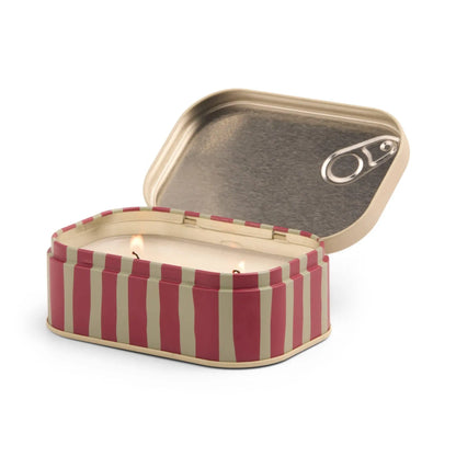 The Meyer Lemon - Bistro 4.5 oz Tin Candle features pink and beige vertical stripes like a sardine can, and opens to reveal a scented candle with two wicks inside.