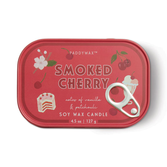 The Smoked Cherry - Bistro 4.5 oz Tin Candle features a red tin with cherries, cherry blossoms, and a cake slice, plus a pull tab. It offers notes of vanilla and patchouli.