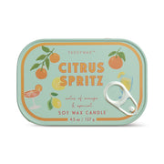 The Citrus Spritz - Bistro 4.5 oz Tin Candle comes in a rectangular sardine tin with a pull-tab lid, decorated with oranges, lemons, cocktails, and leaves, and features notes of orange and apricot on the label.