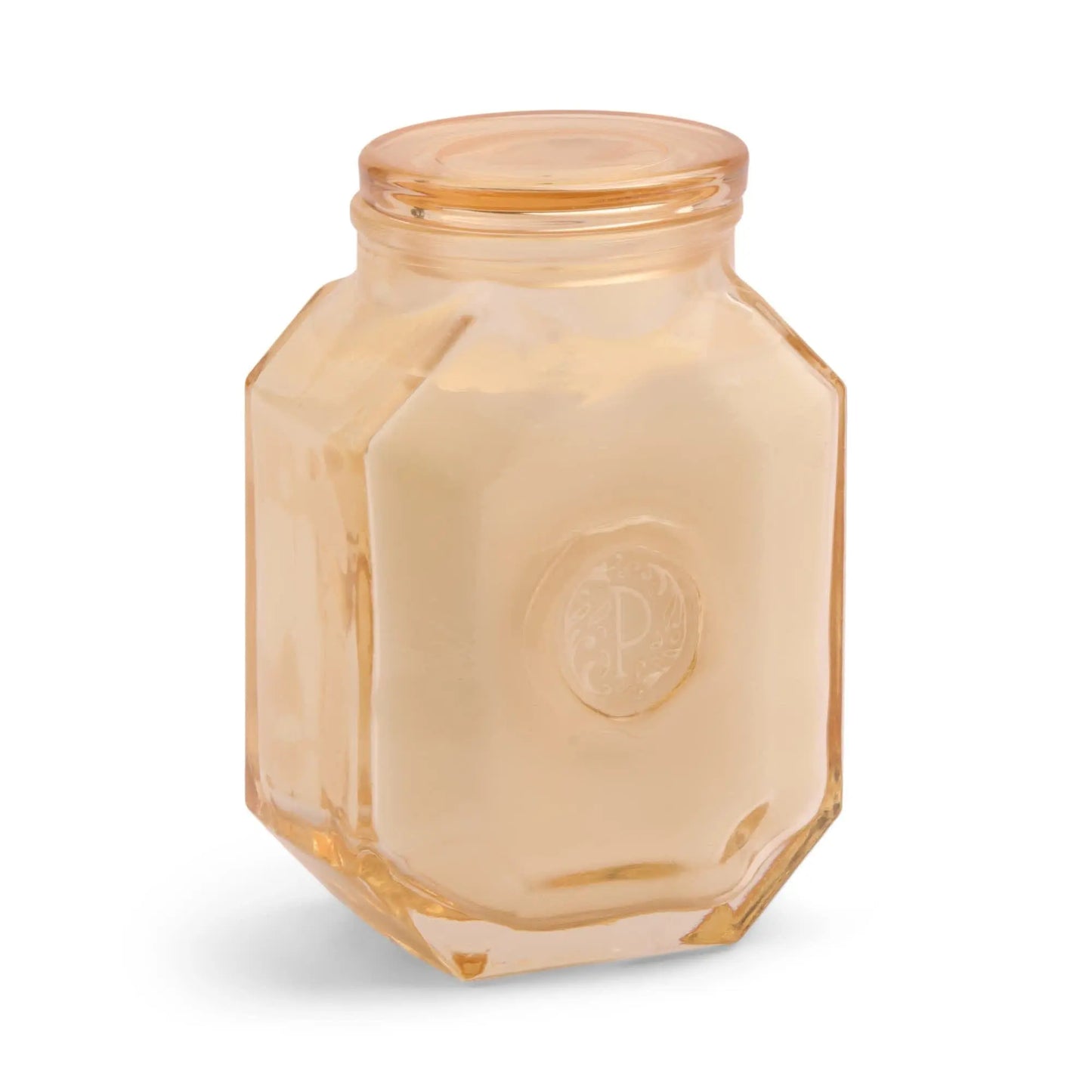The Cotton + Teak - Botanica 8 oz Candle features a hexagonal glass jar with a matching lid and cream-colored wax, offering a luxurious home fragrance experience—perfect for candle lovers.