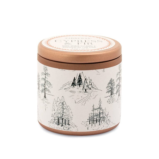 The Cypress & Fir Copper Tin Candle features a round tin with a copper lid and a white label adorned with black line illustrations of trees and mountains, creating a nature-inspired look.