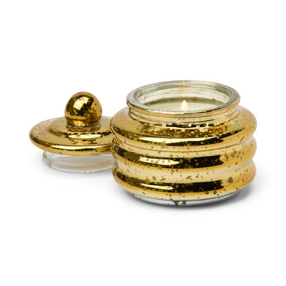 The Cypress & Fir - Beam 3 oz Candle features a gold ribbed glass jar with a lit wick. A matching round lid with a knob sits beside it on a white background—an elegant, gift-ready holiday candle for any occasion.