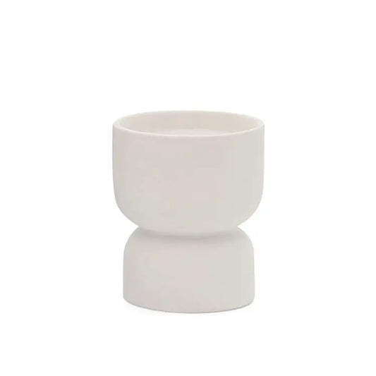 The Tobacco Flower - Form 6 oz Candle features a small, white ceramic hourglass-shaped cup that brings subtle elegance to any setting—ideal for desert-inspired decor with its refined design and clean white finish.