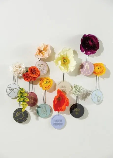 Twelve Violet Vanilla "Thankful For You" Impressions car fragrances, each with colorful artificial flowers and illustrated tags, are arranged in three neat rows on a plain white background.