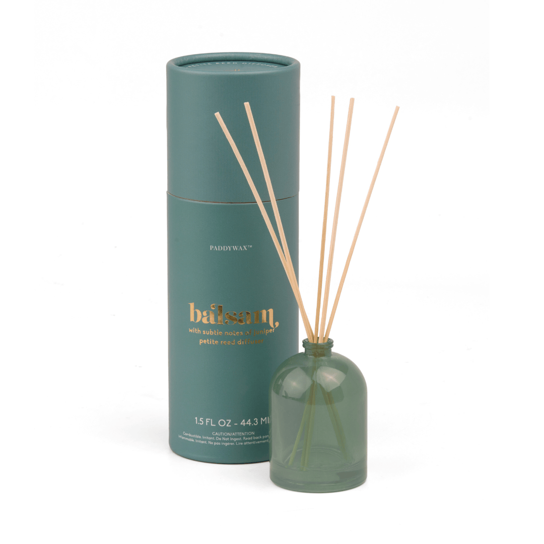 The Balsam - 1.5 oz Diffuser, featuring green milky glass and wooden reeds, stands next to its matching green tube with “balsam” in gold lettering—an elegant set perfect for home fragrance.