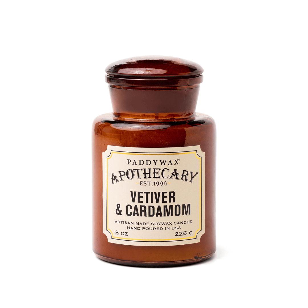 The Vetiver + Cardamom - Apothecary 8 oz Candle is an artisan soy wax candle in a brown amber glass jar, inspired by vintage apothecary bottles.