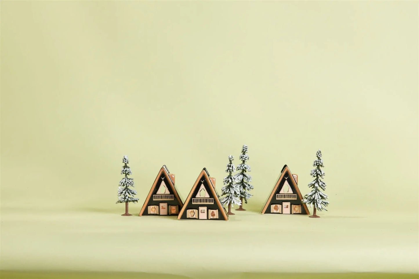 No. 01 The Nordic Cabin - Incense & Tea Light Holder is shown among pine trees and a snowy A-frame cabin village scene on a light yellow background, inspired by Scandinavian décor.