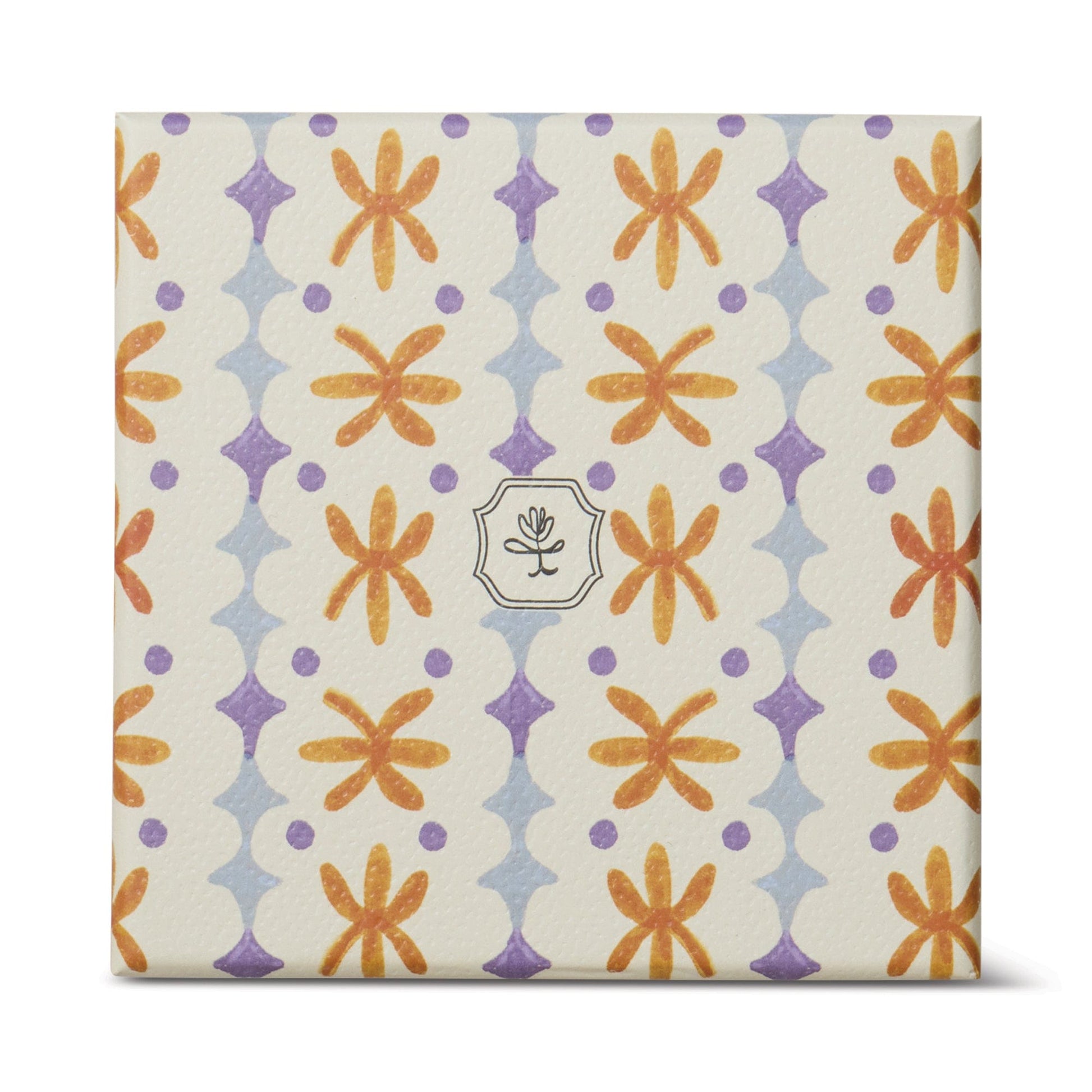 The Garden & Grove - Tulip 5.5 oz Candle comes in a square, cream-colored rustic vessel with orange flowers, purple diamonds, and a central emblem of a simple line flower—ideal for garden-inspired home decor.