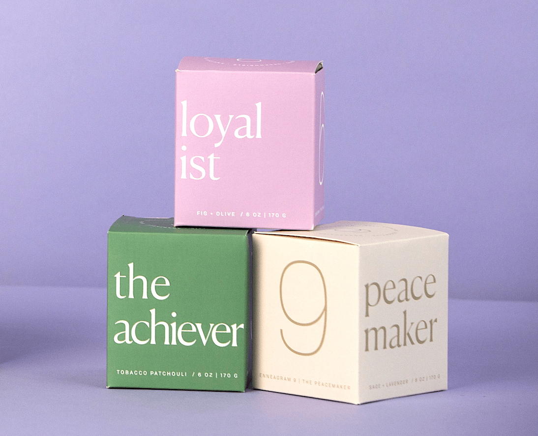 Three pastel-colored boxes are stacked against a purple background. The boxes are labeled loyalist (pink), the achiever (green), and 9 peacemaker (cream), each with additional scent details.