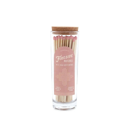 Fireside Safety Matches - Blush: A clear glass match bottle filled with wooden pink-tipped matches, topped with a cork lid. The soft pink and white label reads "Fireside Matches," making it the perfect candle companion.