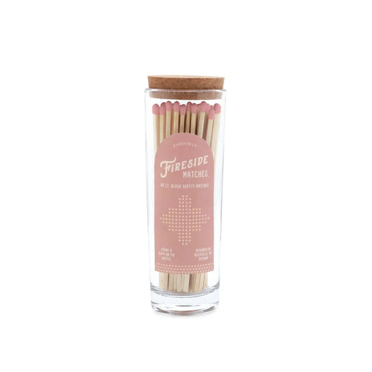 Fireside Safety Matches - Blush: A clear glass match bottle filled with wooden pink-tipped matches, topped with a cork lid. The soft pink and white label reads "Fireside Matches," making it the perfect candle companion.
