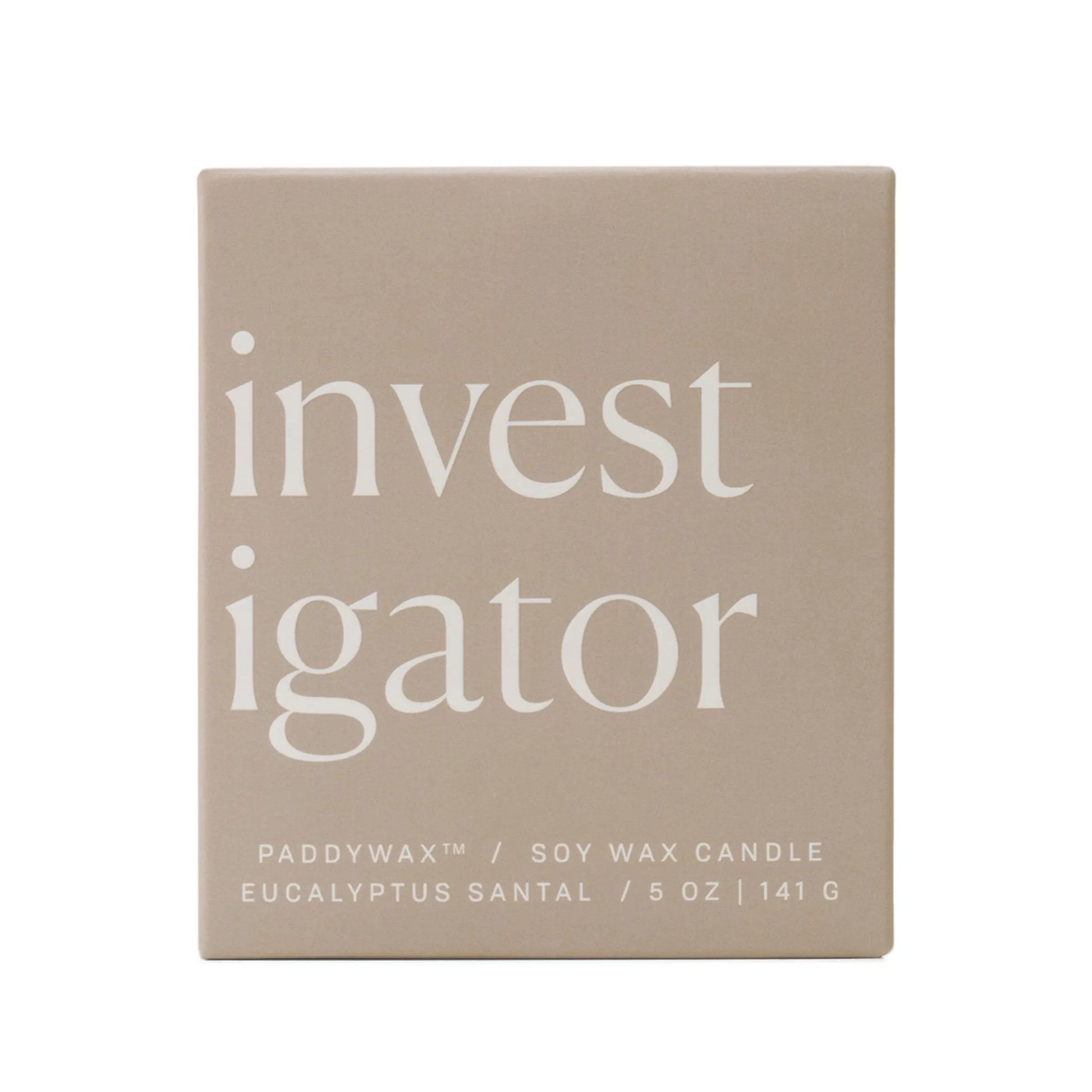 A beige ombre glass box displays "investigator" in bold white letters. Below: Enneagram #5 Investigator 5 oz Candle – Eucalyptus Santal, a Paddywax soy wax candle and thoughtful gift.