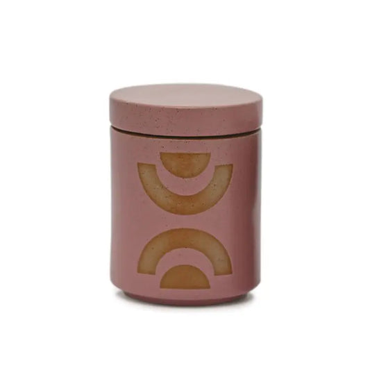 The Mandarin Mango - Form 12 oz Candle comes in a pink ceramic container with a lid and two tan semicircle designs—ideal for home decor or as a chic planter candle.