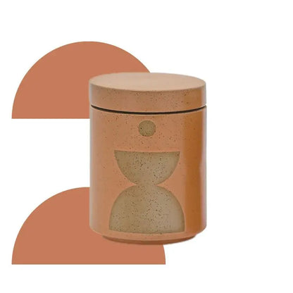 The Wild Fig + Vetiver - Form 12 oz Candle comes in a brown ceramic jar with a lid, featuring minimalist geometric shapes and an arch design in the background.