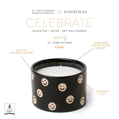 The Black Fig + Olive - St. Jude Giveback "Celebrate" 11 oz. Candle features black soy wax, tan smiley faces, a glossy glaze, exposed clay, and "Inspired by St. Jude Patient Chase" inside—a heartfelt Paddywax x St. Jude collaboration.