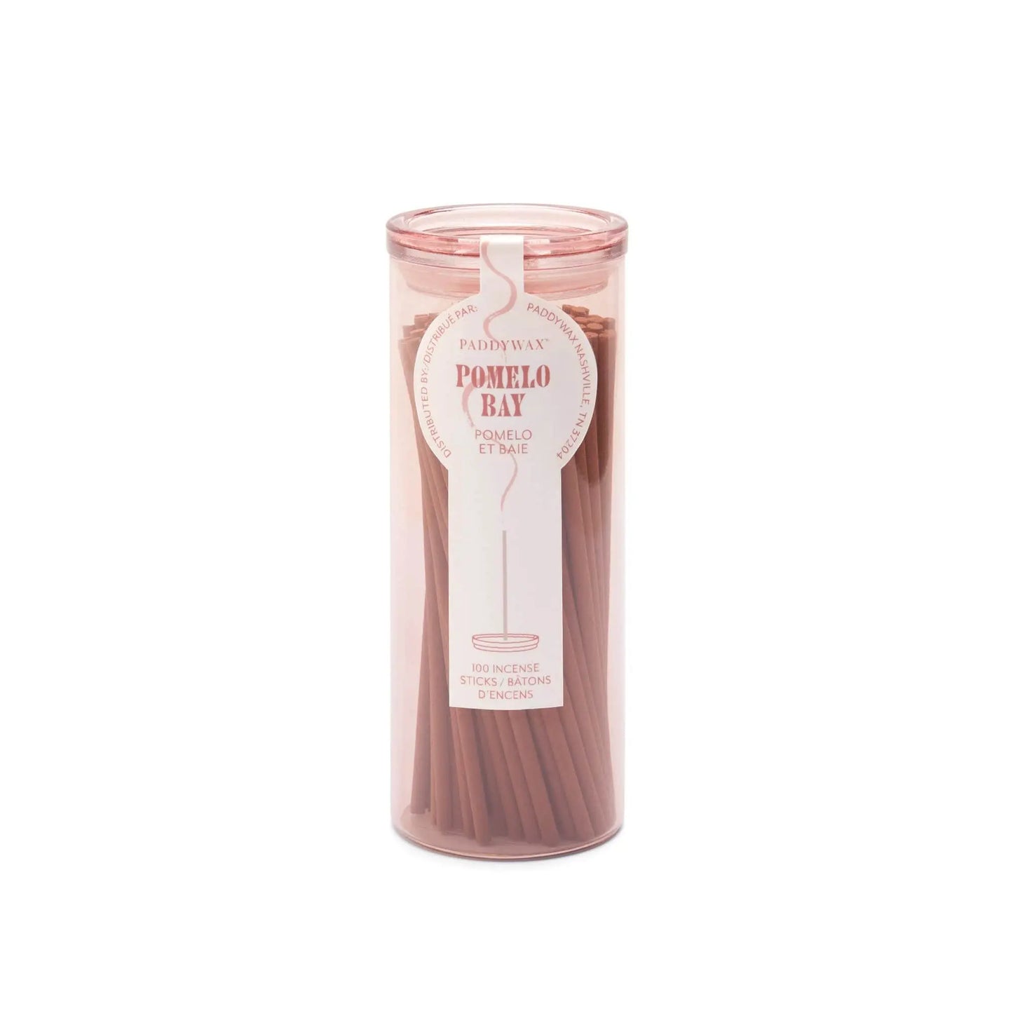 A clear cylindrical holder with a pink lid contains pink Pomelo Bay - Haze Incense sticks. The label highlights the flameless fragrance and states it holds 100 sticks from the incense collection.