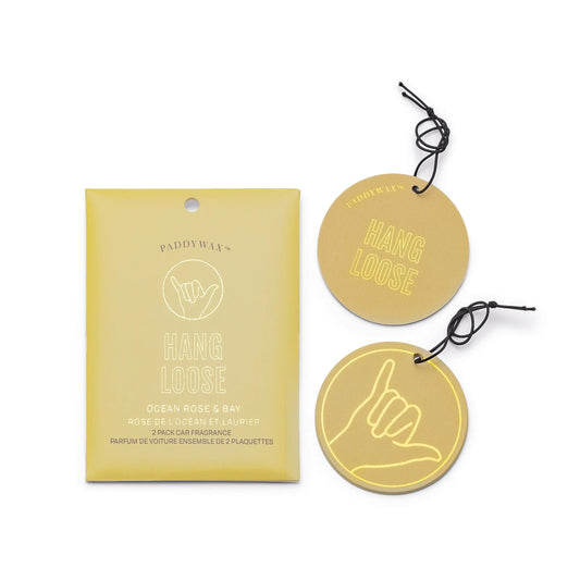 The Ocean Rose + Bay "Hang Loose" Impressions Car Fragrance set includes two gold round car air fresheners with a shaka hand design and comes in matching gold packaging.