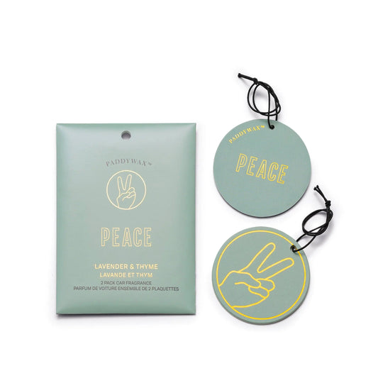 Two round green "Peace" Lavender + Thyme Impressions Car Fragrances with a hand peace sign, next to matching packaging. Perfect for refreshing your ride with this calming scent.