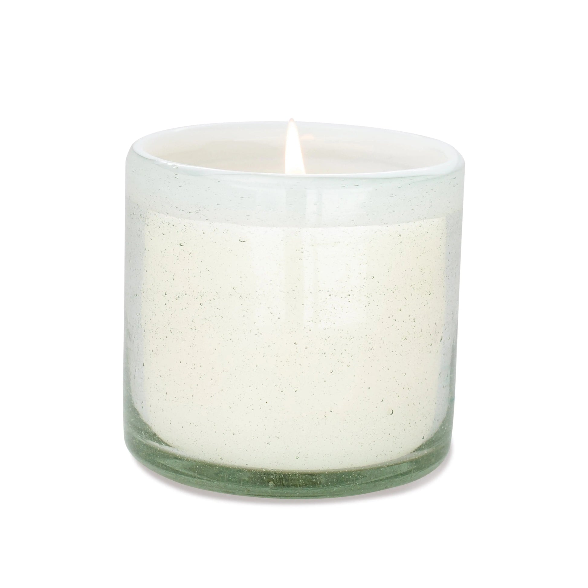 The Amber + Coconut - La Playa 9 oz Candle glows in a clear, hand-blown bubble glass container against a plain white background.