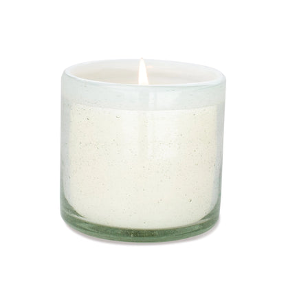 The Amber + Coconut - La Playa 9 oz Candle glows in a clear, hand-blown bubble glass container against a plain white background.