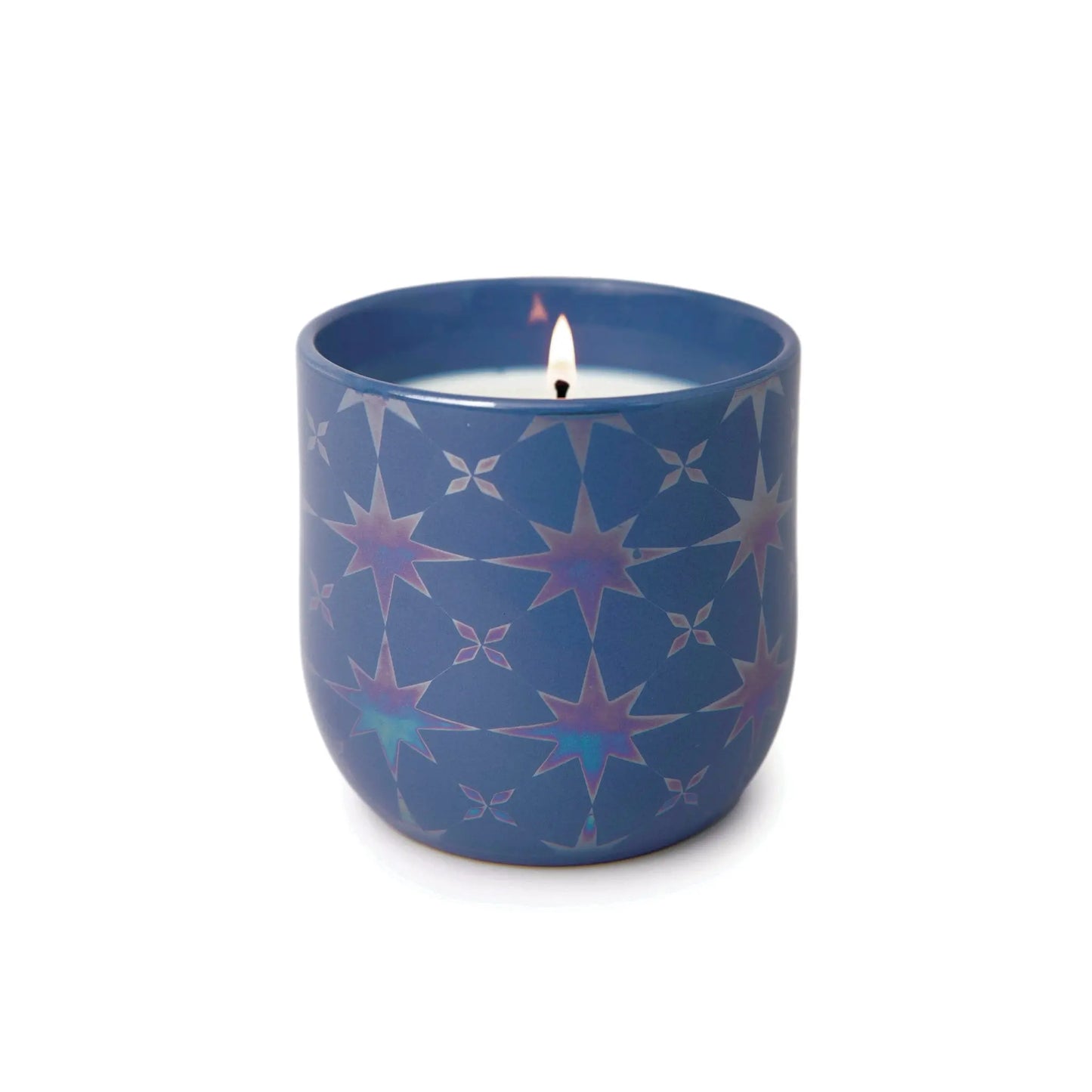 A lit Sapphire Waters - Lustre Candle 10 oz in a blue holder with iridescent star patterns, set against a plain white background.