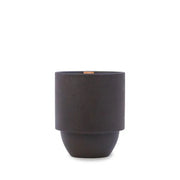 A matte black cylindrical planter with a slightly narrower base sits beside the Yosemite - Parks 11 oz Candle, which offers a woody Cottonwood and Oak scent and a crackling wood wick, both shown against a plain white background.