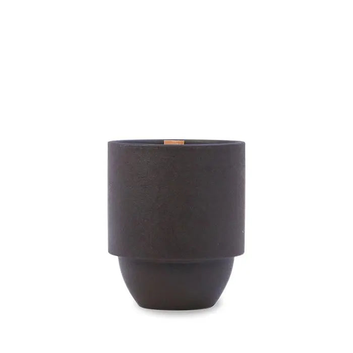 A matte black cylindrical planter with a slightly narrower base sits beside the Yosemite - Parks 11 oz Candle, which offers a woody Cottonwood and Oak scent and a crackling wood wick, both shown against a plain white background.