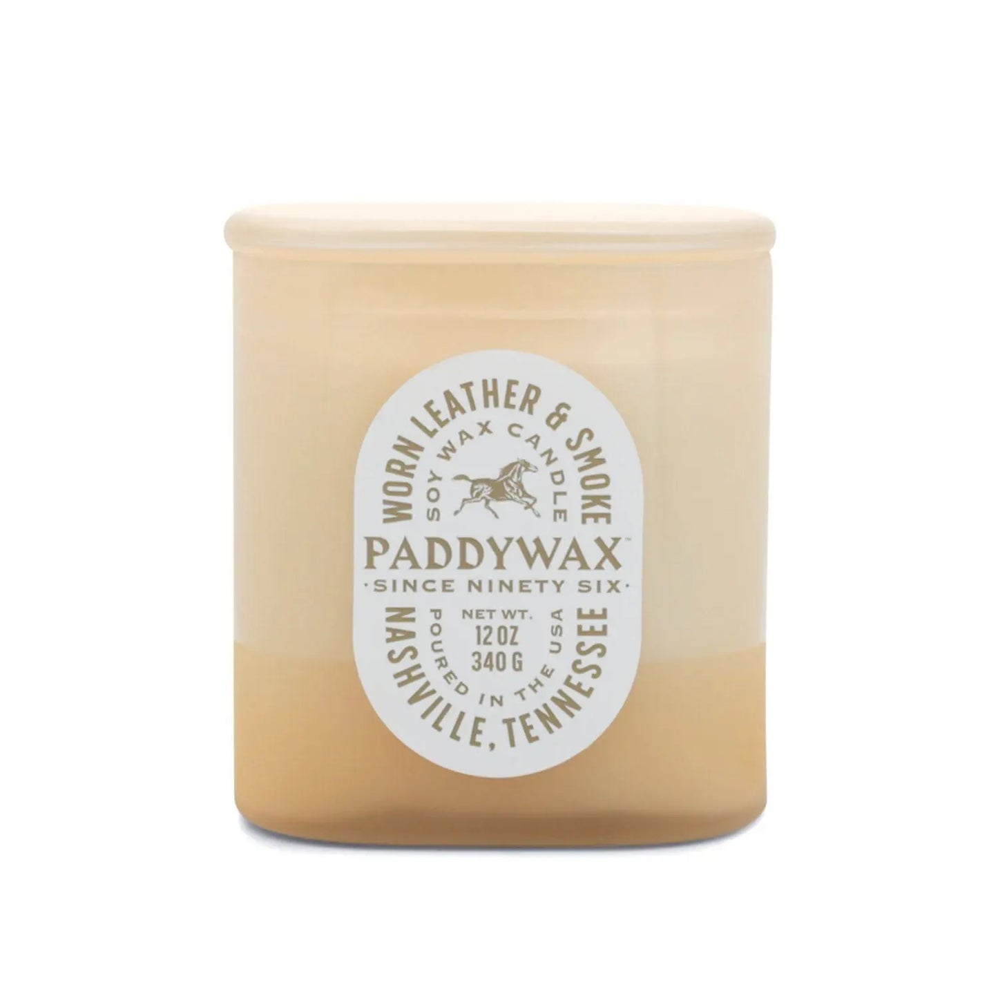 The Worn Leather + Smoke - Vista 12 oz Candle by Paddywax features cream and tan tonal glass, a white oval label, vintage-inspired design, and is made in Nashville, Tennessee.