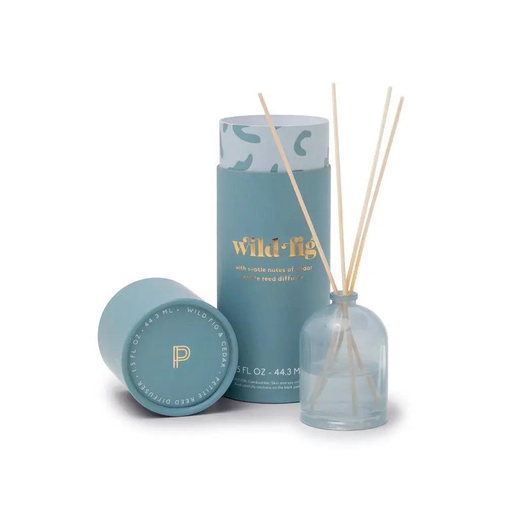 The Wild Fig - 1.5 oz Diffuser features a blue cylindrical box and matching lid alongside a clear diffuser with fragrance sticks, making it an ideal gift.